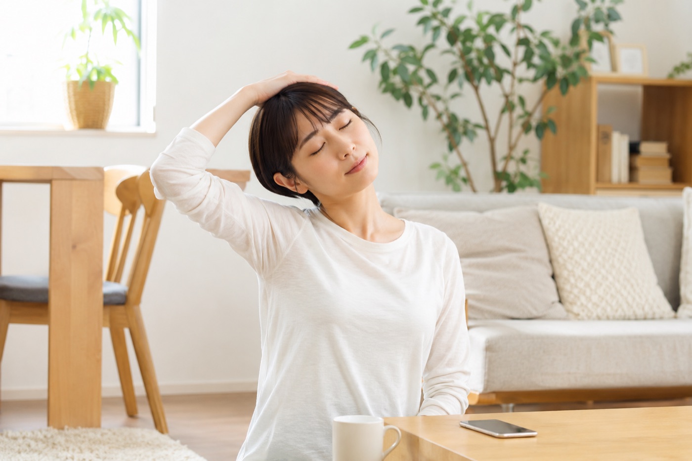 首や肩まわりに手を添える女性